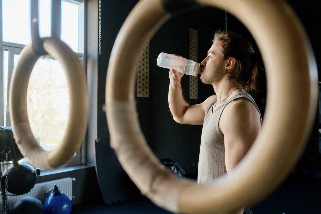 personal trainer drinks waterto recover after workout